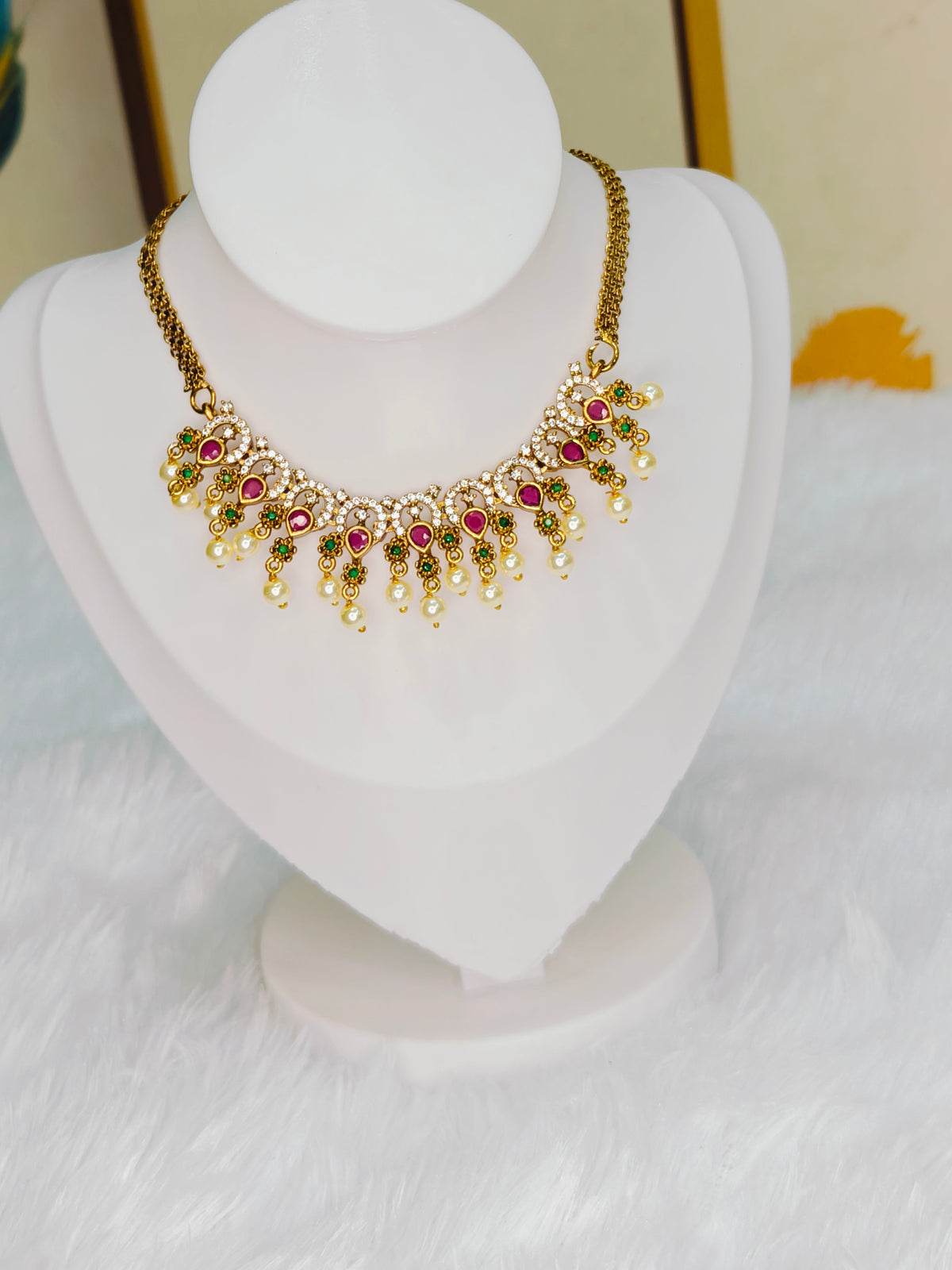 Traditional Kemp stone details, including ruby and emerald accents with pearl drops.