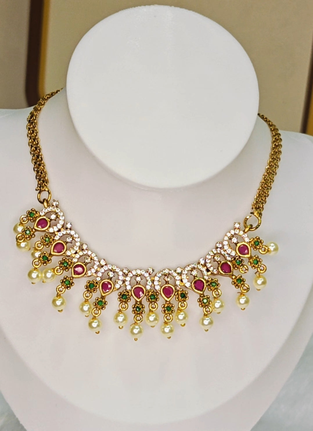Traditional Kemp stone details, including ruby and emerald accents with pearl drops.
